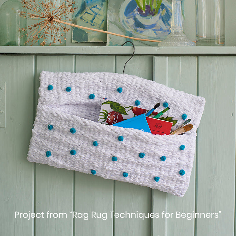 White peg loom woven beginners project bag made from an old sheet with blue pom poms